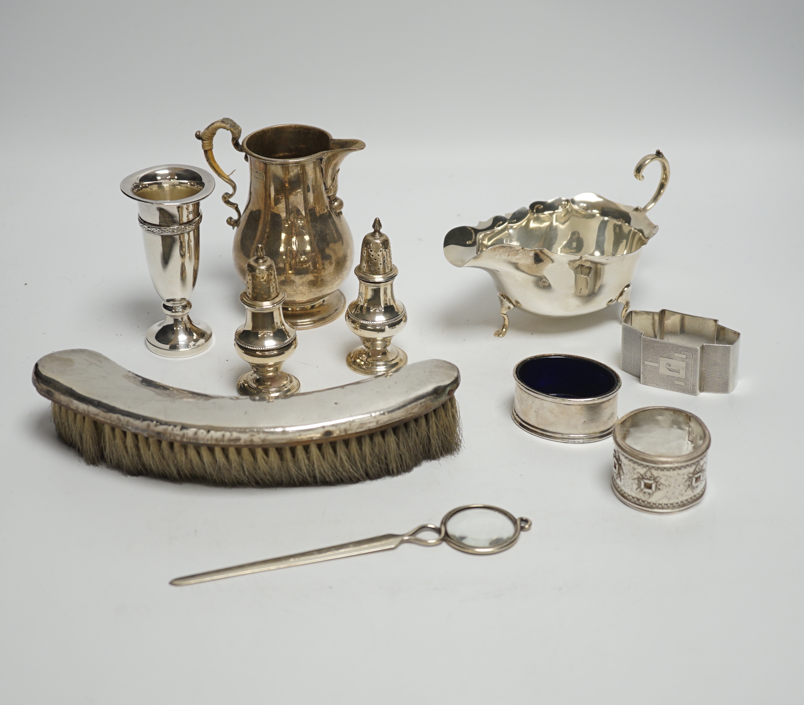 Sundry small silver including a silver sauceboat, George V sparrow beak cream jug, pair of pepperettes, napkin rings etc. and a letter opener/magnifying glass by Charles & George Asprey, London, 1908.